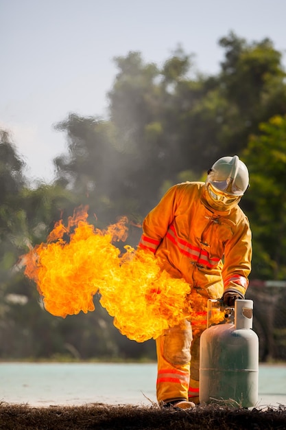 Bombero con fuego y traje para proteger al bombero para entrenar a los bomberos