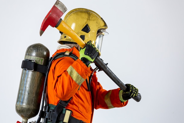 Foto bombero con hacha en manos uniforme y casco bombero con equipo de extinción de incendios