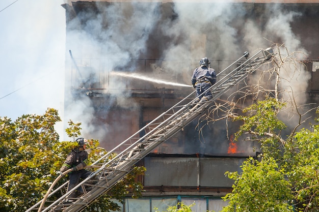 Los bomberos extinguen un incendio en un edificio residencial de gran altura.