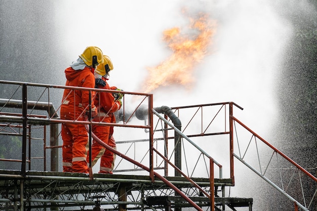 Los bomberos o los bomberos usan extintores y rocían agua a alta presión desde la manguera para controlar el fuego