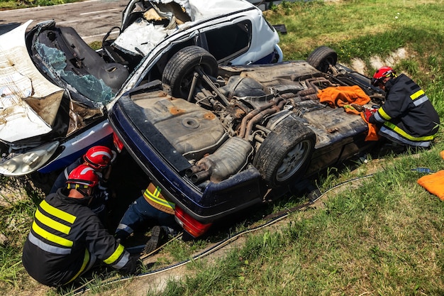 Bomberos tratando de liberar al hombre del coche accidentado.