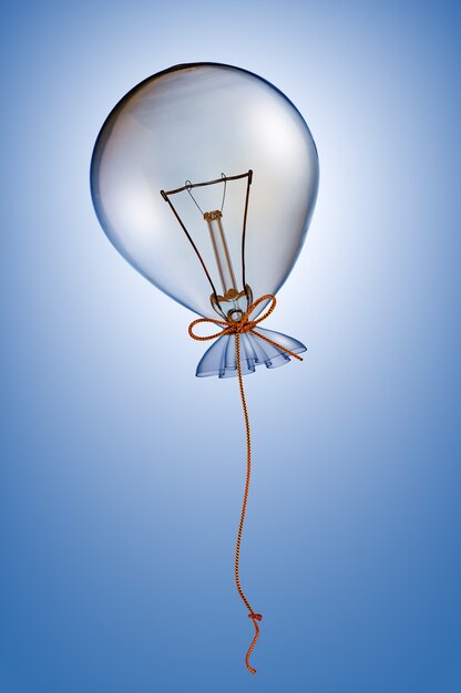 Foto bombilla de globo con cinta sobre fondo azul.