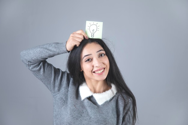 Bombilla de luz de mano de mujer feliz sobre papel