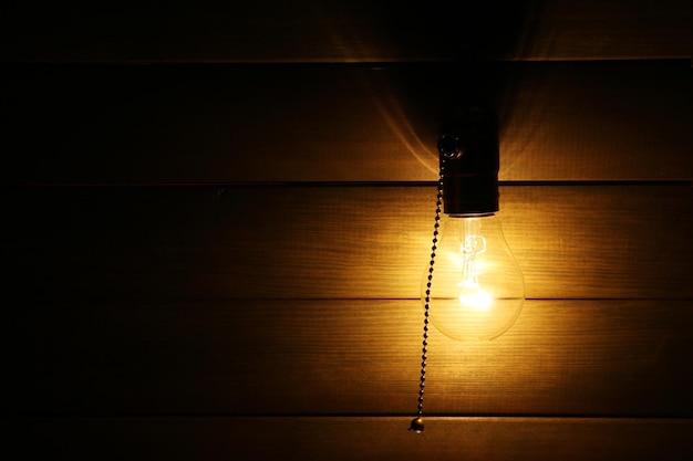 Bombilla de luz sobre fondo de madera de cerca