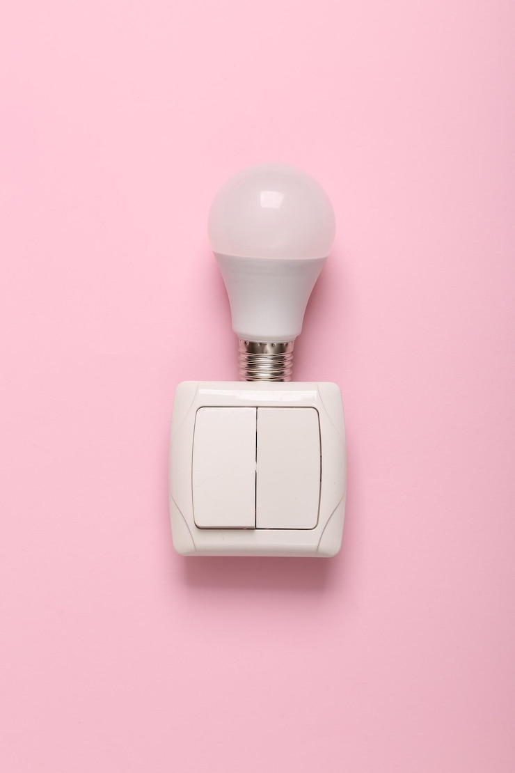 Foto una bombilla que está en una pared rosa