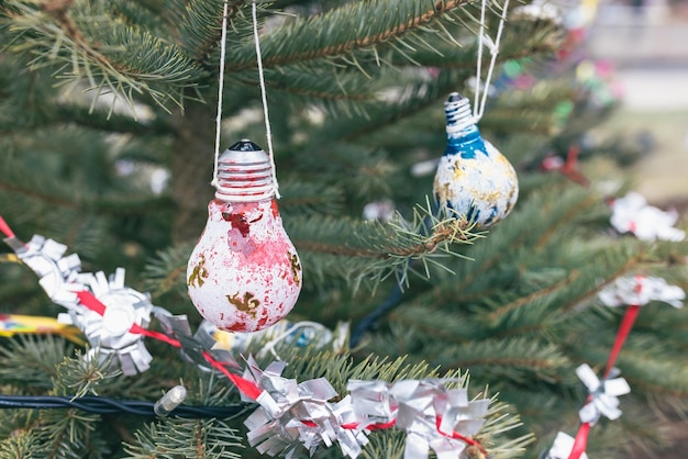 Bombillas eléctricas viejas pintadas de rojo y azul en la decoración de bricolaje del árbol de Navidad