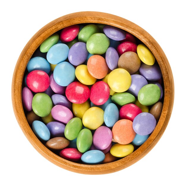 Bombones de colores en cuenco de madera