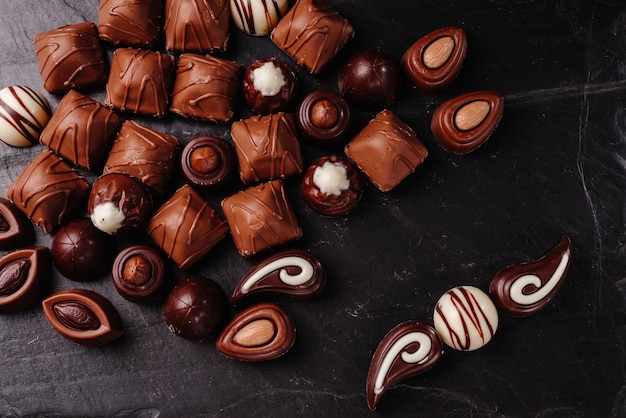 Bombons de chocolate com vários recheios, mistura de fundo de alimentos doces e conjunto de combinações de doces diferentes