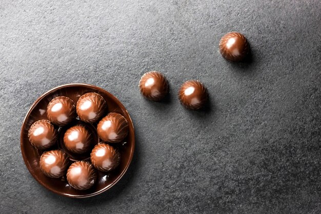 Bombons de chocolate num prato preto com espaço de cópia