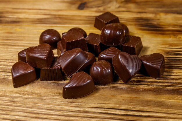 Bombons de chocolate saborosos na mesa de madeira