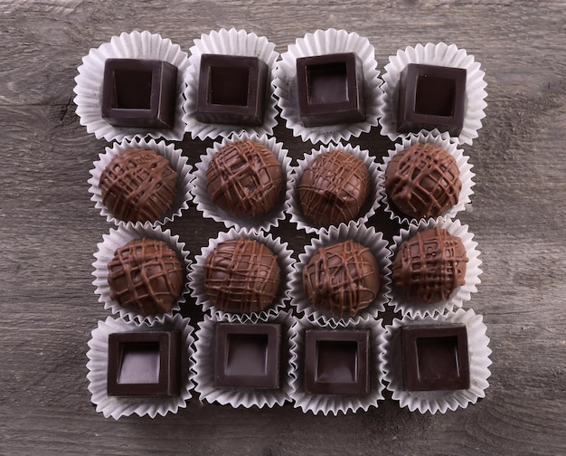 Bombons de chocolate sortidos em fundo de madeira