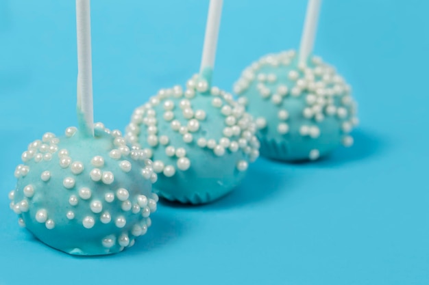 Foto bonbons auf stöcken blaue kuchen auf blauem hintergrundschönes süßes dessert