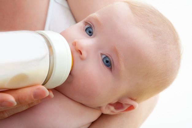 Foto bond pequeños ojos azules bebiendo leche de biberón