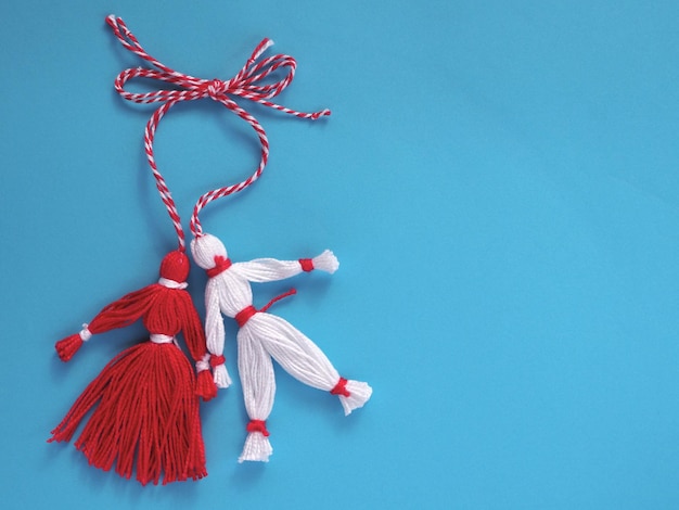 Bonecas Martisor vermelhas e brancas sobre um fundo azul