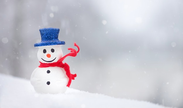 Boneco de neve com lenço vermelho sobre fundo branco de neve Férias de inverno Tempo de Natal Copie o espaço