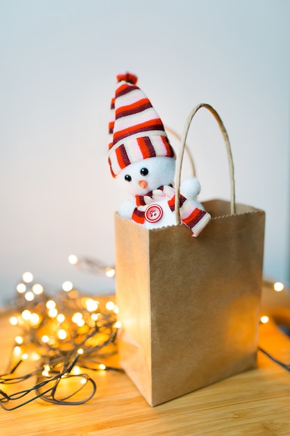 Boneco de neve de brinquedo de Natal encontra-se no pacote de ofício no contexto da guirlanda de Natal