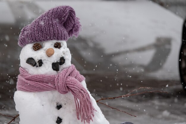Boneco de neve engraçado no elegante chapéu preto no campo nevado.
