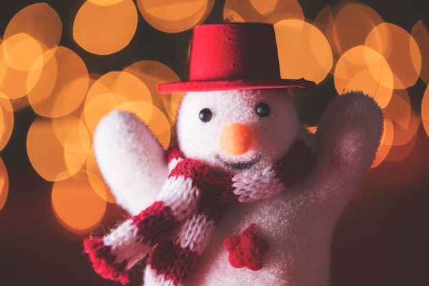 Boneco de neve festivo com chapéu e cachecol contra luzes de fadas bokeh turva