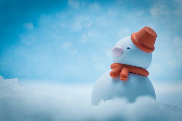 Boneco de neve na neve e bokeh de fundo