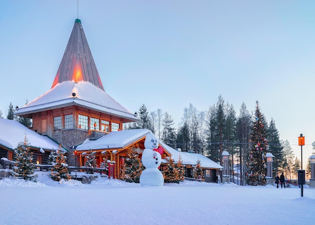 Boneco de neve no escritório do Papai Noel na Aldeia do Papai Noel, Rovaniemi, Lapônia, Finlândia, no Círculo Polar Ártico no inverno. Ao pôr do sol da tarde