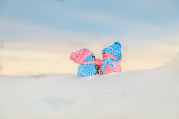 Bonecos de neve caseiros bonitos com lenços e chapéus na montanha. conto de inverno. cartão com espaço de cópia. fundo de inverno.