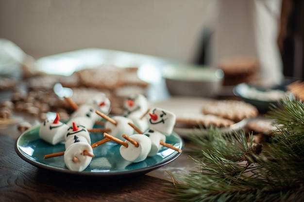 Bonecos de neve de marshmallow mentem sobre um prato. Preparando-se para o Natal. Decoração de cacau.