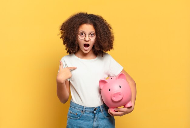 Bonita adolescente afro sonriendo y mirando amistosamente, mostrando el número cuatro o cuarto con la mano hacia adelante, contando hacia atrás. concepto de ahorro