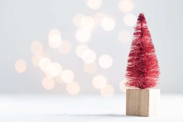 Bonita árvore de Natal em miniatura em uma mesa branca com luzes bokeh