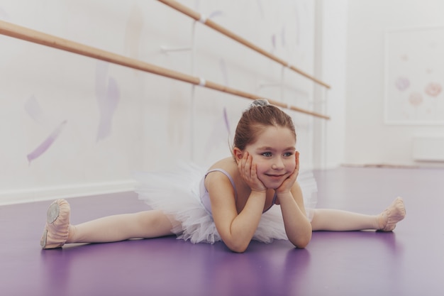 Bonita bailarina feliz fazendo racha na escola de dança.