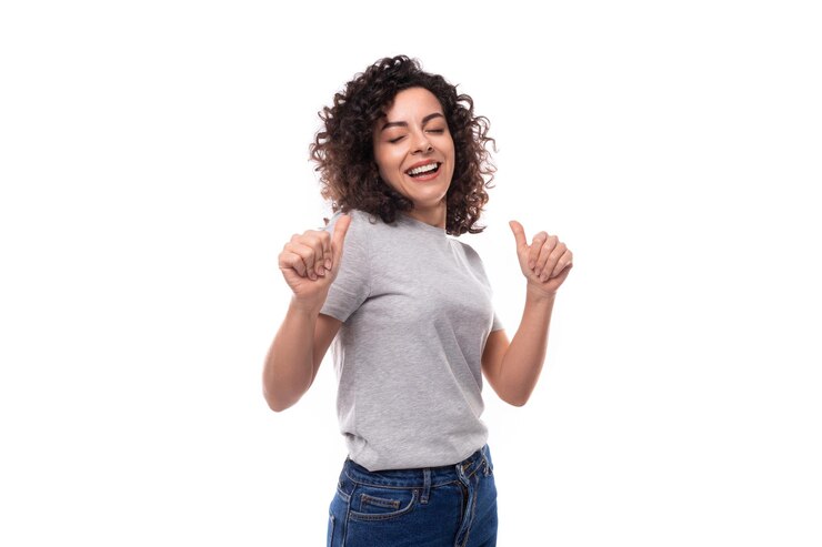 Foto bonita caucásica joven mujer morena con el cabello rizado vestido con una camiseta gris con una maqueta en un