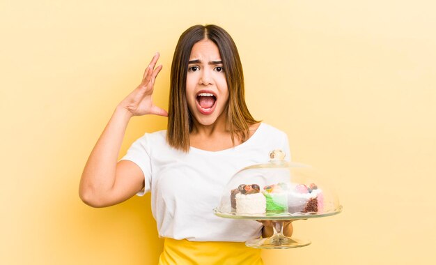 Bonita chica hispana gritando con las manos en el aire concepto de pasteles caseros