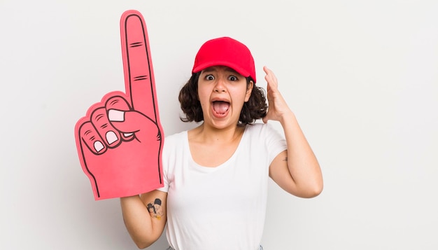 Bonita chica hispana gritando con las manos en el aire concepto de ventilador de mano número uno