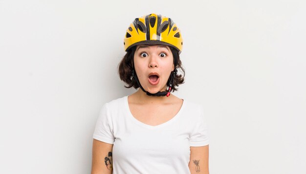 Bonita chica hispana que parece un concepto de bicicleta muy conmocionada o sorprendida