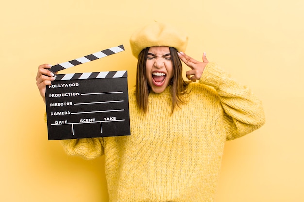 Bonita chica hispana que parece infeliz y estresada gesto de suicidio haciendo el concepto de cine de signos de pistola