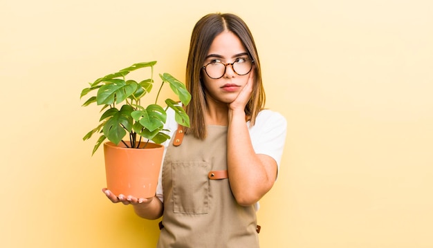 Bonita chica hispana que se siente aburrida, frustrada y somnolienta después de un concepto de planta agotador