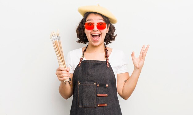 Bonita chica hispana que se siente feliz y asombrada por algo increíble concepto de estudiante de arte