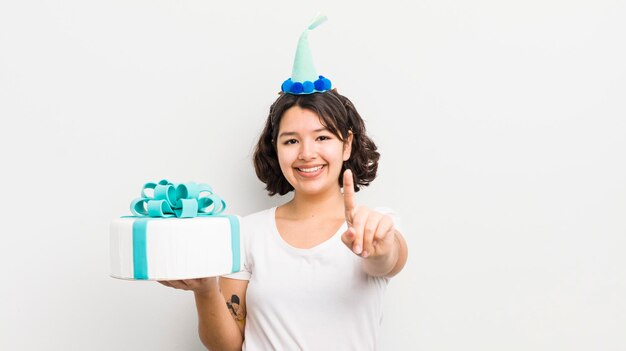 Bonita chica hispana sonriendo y luciendo amigable mostrando el concepto de cumpleaños número uno