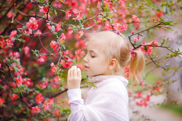 Bonita chica rubia cerca del árbol de flor