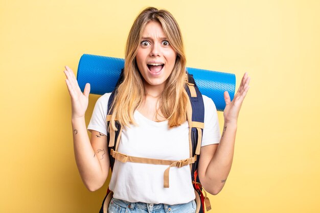 Bonita chica rubia que se siente feliz y asombrada por algo increíble. concepto de excursionista