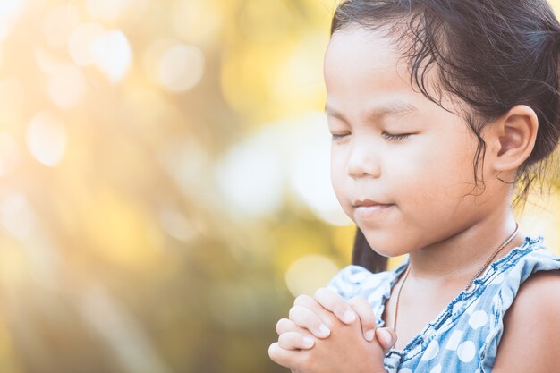 Bonita criança asiática recém com dobrada a mão para o conceito de fé, espiritualidade e religião