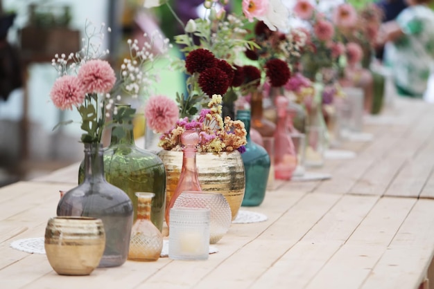 Bonita decoración con flores y jarrones de cristal de colores.