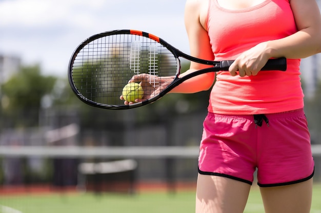 Bonita deportista con raqueta en la cancha de tenis. Estilo de vida saludable