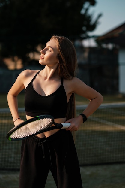 Bonita desportista com raquete na quadra de tênis Estilo de vida saudável