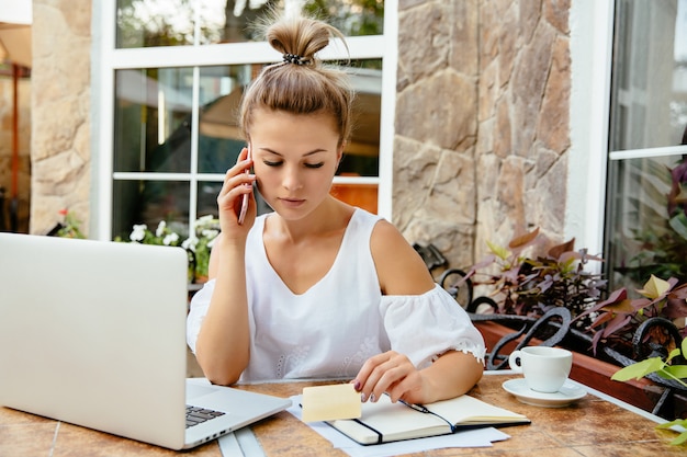 Bonita empresária com cartão de crédito, falando pelo telefone celular