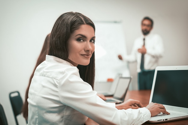 Bonita empresaria trabajando en equipo portátil en el lugar de trabajo.