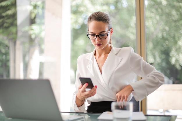 Bonita empresária verificando seu telefone