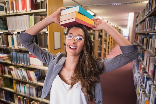 Bonita estudiante con libros en la biblioteca