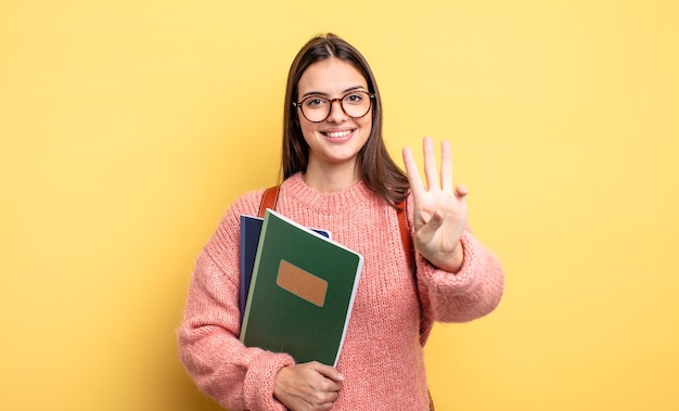 Bonita estudiante mujer sonriendo y luciendo amigable, mostrando el número tres