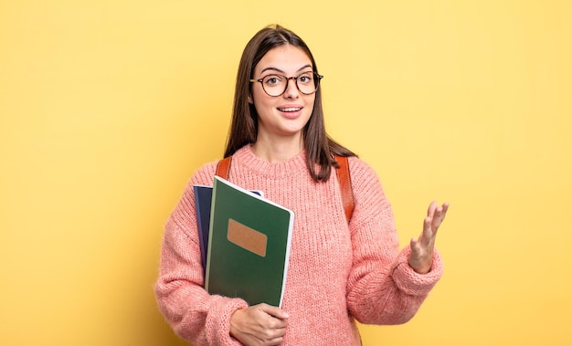 Bonita estudiante que se siente feliz, sorprendida al darse cuenta de una solución o idea