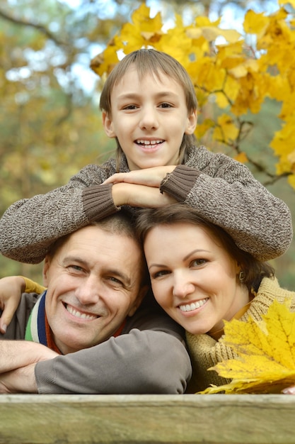 Bonita familia feliz en el parque de otoño